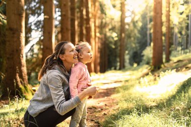 Anne kız sonbahar ormanlarında kaynaşıyor, doğanın ve birbirlerinin arkadaşlığının tadını çıkarıyor..
