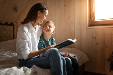 Anne oğluyla evde kitap okuyor. Aile bağı. 