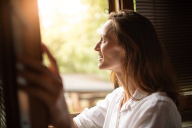 Pencereden dışarı bakan mutlu kadın. Günaydın.. 