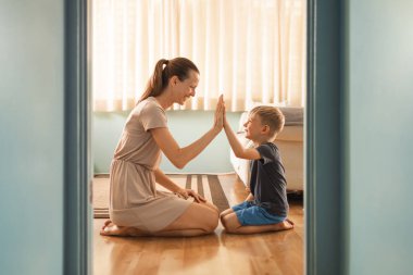 Mutlu anne ve oğul birlikte çalışarak, beşlik çakarak, iyi ebeveynlik kavramı 