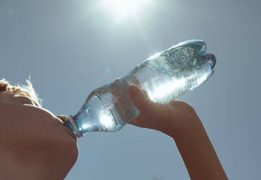 Bir şişe su, içme suyu, diyet ve sağlık konsepti tutan kişi