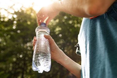 Bir şişe su, içme suyu, diyet ve sağlık konsepti tutan kişi