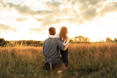 Babası ve küçük kızı gün batımını izliyorlar, ebeveynlik, aile bağları. 