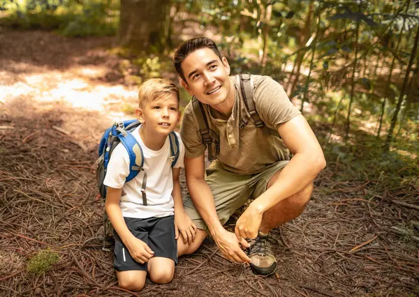 Küçük çocuk ve babası birlikte doğa keşfi yapıyorlar. Baba oğul, güneşli yaz ormanlarında ailece güzel vakit geçiriyor. Babası ve küçük oğlu.
