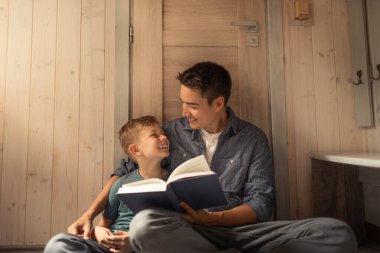 Baba oğul kitap okuyor, hikaye zamanı, eğitim ve evde öğrenme. Hikaye anlatmak, mutlu olmak ve çocuk bakımını, aile eğitimini ve gelişimini rahatlatmak için...