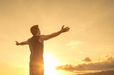 Dağlardaki neşeli genç adam umut dolu duygularla gökyüzüne bakıyor..