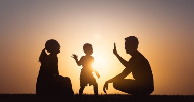 Gün batımında gökyüzünde baba ve oğul silueti