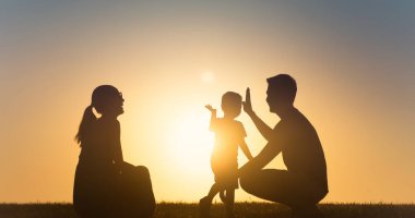 Gün batımında gökyüzünde baba ve oğul silueti