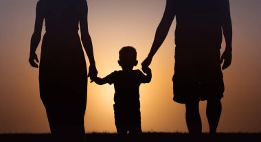 Gün batımında gökyüzünde baba ve oğul silueti