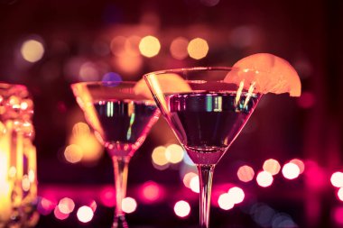 Masanın üzerinde bulanık arkaplanı olan bir bardak martini..