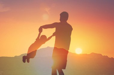 Mutlu baba oğluyla oynuyor ve onu havada tutuyor. Baba oğul ilişkisi konsepti.