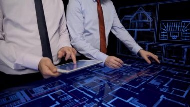 Architects in office looking blueprints on monitors