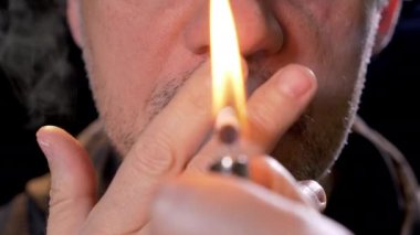 Smoker lights up a cigarette