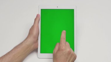 Yeşil ekranlı dijital tablet kullanan bir adam