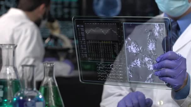 실험실에서 미래론적 타블렛을 사용하는 과학자 — 비디오