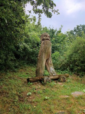 Büyükbaba şeklinde ahşap heykeli olan bir bank.