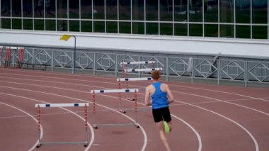 men athletes running 400 meter hurdles race