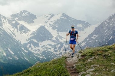 Arkhyz, Russia - July 2, 2022: male athlete walking mountain trail in Arkhyz X Run