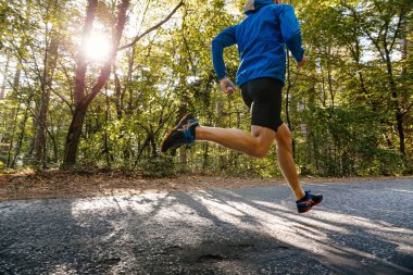 Sochi, Russia -  September 19, 2017: male runner running asphalt road in Asics shoes