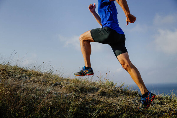 Sochi, Russia -  September 19, 2017: male runner running uphill in Asics shoes