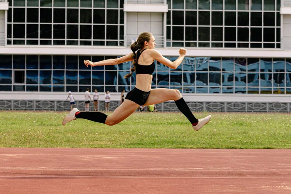 female athlete triple jump on track stadium
