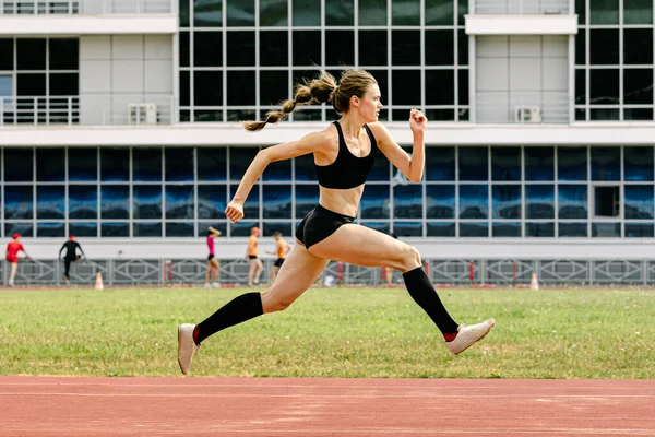 Young Female Athlete Jumping Track Stadium — стоковое фото