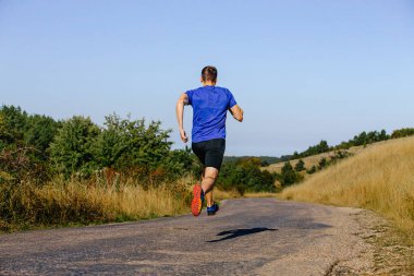 back male runner running on road on plain