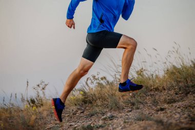 legs male runner running on mountain trail
