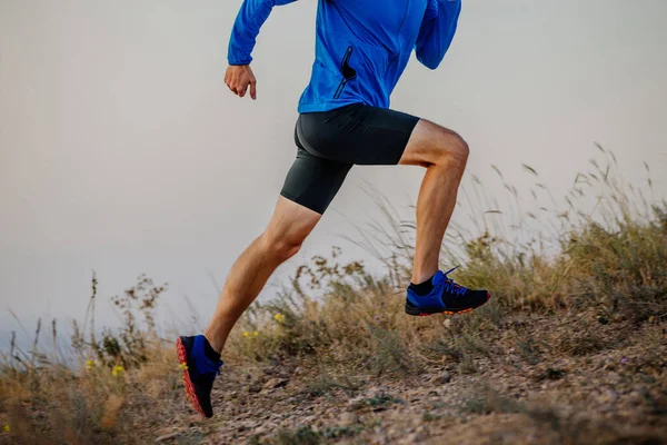 legs male runner running on mountain trail