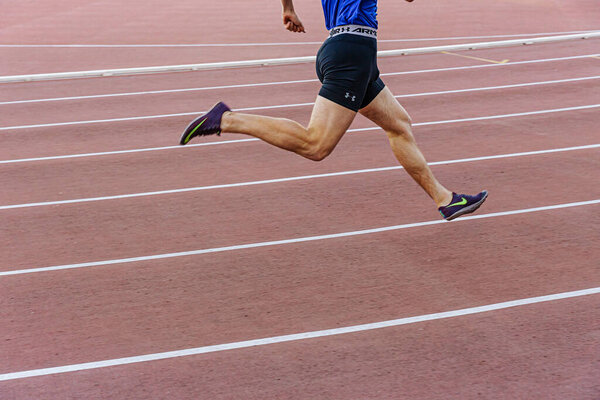 male runner athlete run sprint race, Nike running spikes shoes and Under Armour shorts, sports editorial photo