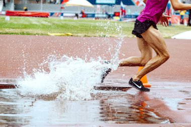 athlete runner running steeplechase in Nike spikes shoes, world championship athletics competition, sports editorial photo clipart