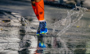Mizuno ayakkabılarıyla koşan atlet ve su üzerinde çalışan CEP sıkıştırma çorapları, şehir maratonu yarışı, spor editörü fotoğrafı