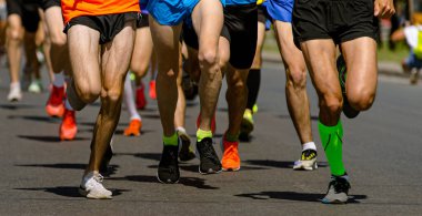Yakın plan bacak koşucuları spor maratonu, asfalt yolda erkek koşu yarışı, atletizm yarışması