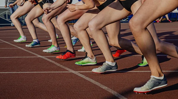 腿女运动员在中长跑 夏季奥运会的起跑线上穿跑鞋 — 图库照片