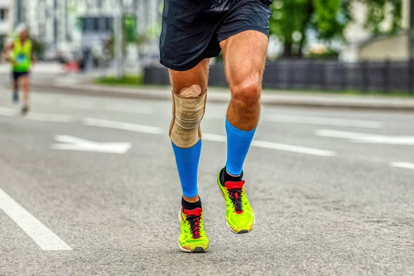 膝パッドの脚男ランナーとマラソンを走る圧縮靴下安定化のための負傷後の膝袖の保護 — ストック写真