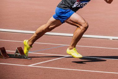 Bacak sprinter koşucusu başlangıç bloklarından başlıyor. Koşu pistinde, yaz atletizm şampiyonasında.