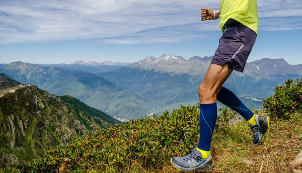 圧縮ソックスの足ランナー選手が山を駆け下り — ストック写真