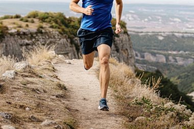 rangy male runner run on mountain trail, muscular legs man jogger athlete running narrow path clipart