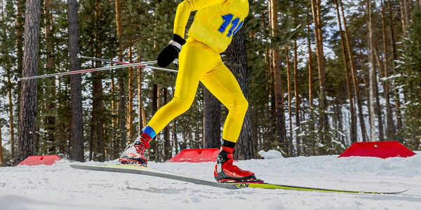 明るい黄色の肌のスーツと赤いスキーブーツでクロスカントリースキーを実行している男性アスリートスキー — ストック写真