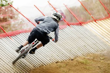 Dikiz manzaralı dağ bisikletçisi yırtıkları yokuş aşağı yarışında eğimli bir köşeyi döner, yaz aşırı sporları.