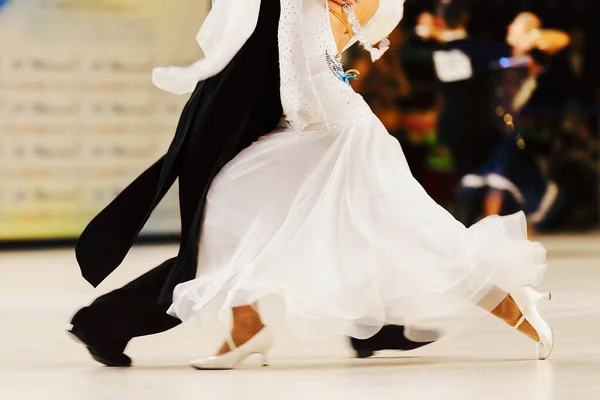 社交ダンスのスポーツでタンゴを踊るパートナー女性は白いドレスと黒い尾のスーツを身に着けている男 — ストック写真