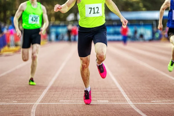男子アスリートランナーは陸上競技選手権でフィニッシュラインスプリントレースを渡り — ストック写真