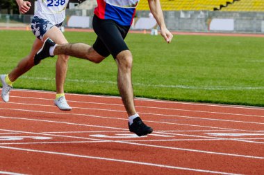 Erkek koşucu sprint yarışı bitiş çizgisinde koşar, yaz atletizm şampiyonası