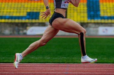 Nike sprinter koşu stadyumunda koşan bayan atletizm ayakkabıları, yaz atletizm şampiyonası, alt bacağında kinesiotaping