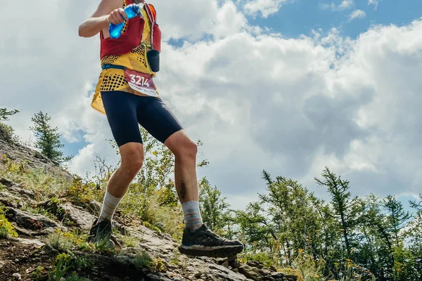 Atlet dik dağ yamacından aşağı koşuyor, yaz maratonu