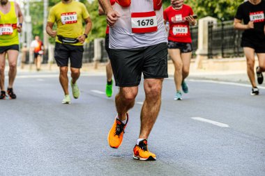 Erkek atlet önde koşuyor grup koşucuları maratonu