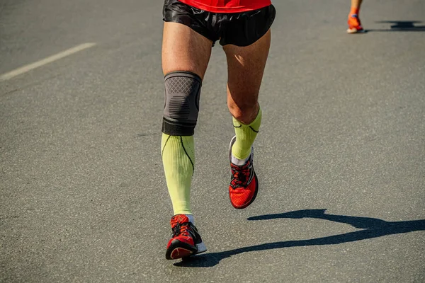 Nahaufnahme Beine Männlichen Läufer Kompressionsstrümpfen Und Knieschoner Laufen Marathonlauf Sport — Stockfoto