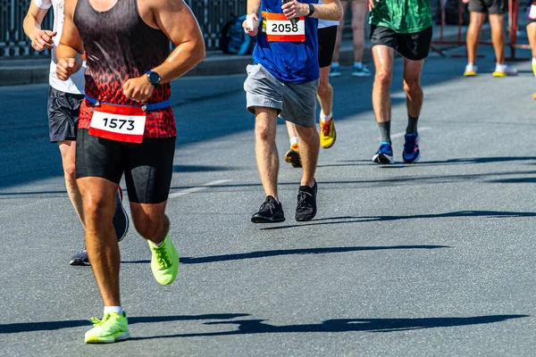 侧观组男子赛跑选手一起参加马拉松比赛 阴影笼罩在灰色柏油路上 — 图库照片