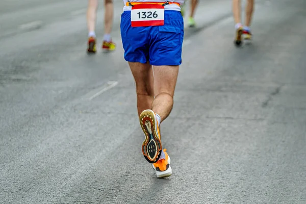 リアビューソールランニングシューズ男性ランナーはグレーアスファルトでマラソンレースを実行します — ストック写真
