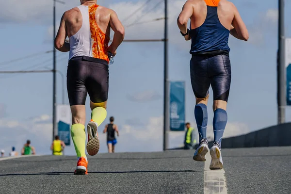 リアビュー道路上のマラソンレースを実行している圧縮靴下の2人の男性選手 夏のスポーツイベント — ストック写真